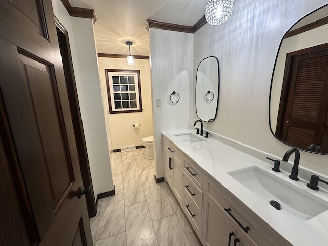 bathroom featuring ornamental molding, a notable chandelier, vanity, and toilet