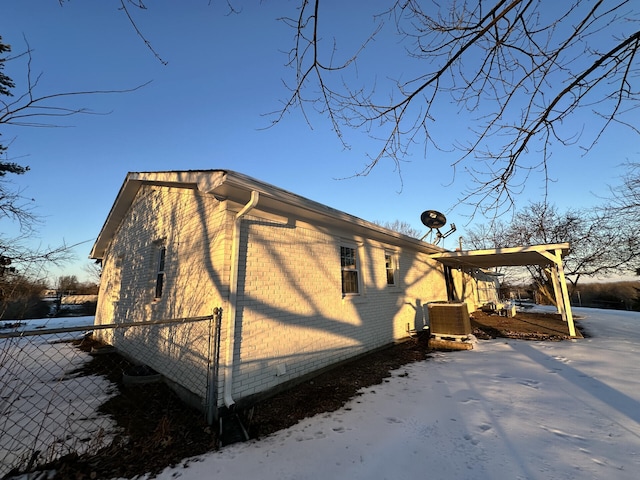 view of snow covered exterior featuring central AC unit