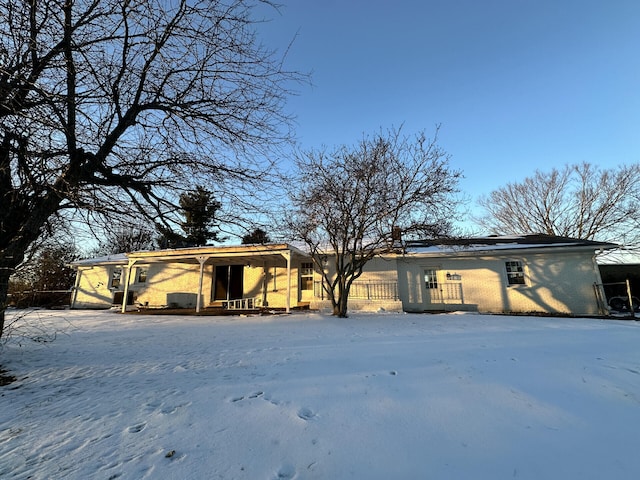 view of snow covered back of property