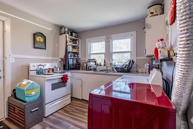 kitchen featuring sink, white cabinetry, white range with electric stovetop, and light hardwood / wood-style flooring