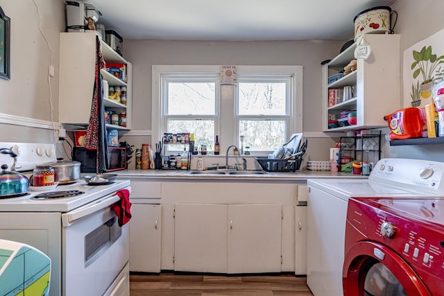 kitchen with white electric range oven, hardwood / wood-style flooring, white cabinets, washer and clothes dryer, and sink