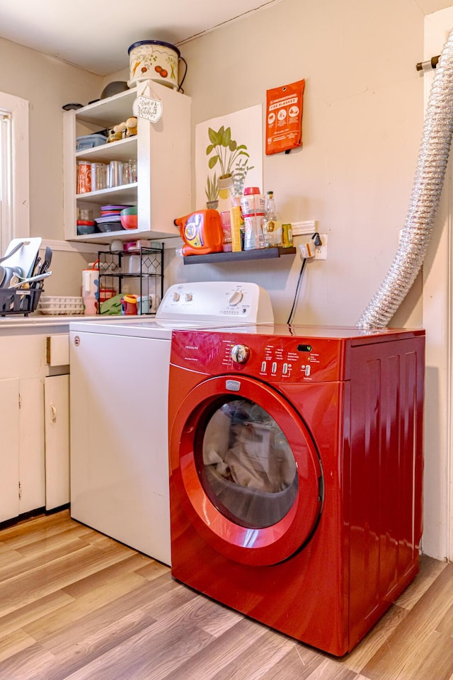 clothes washing area featuring washer and dryer and light hardwood / wood-style flooring