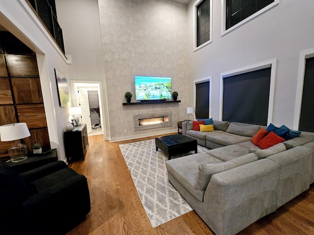 living room featuring a towering ceiling and wood-type flooring