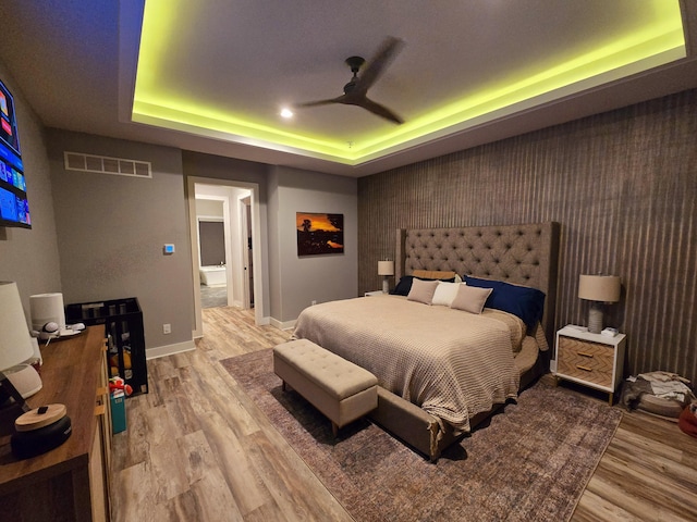 bedroom featuring light wood-type flooring and a tray ceiling