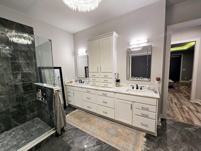 bathroom featuring vanity, an inviting chandelier, and walk in shower