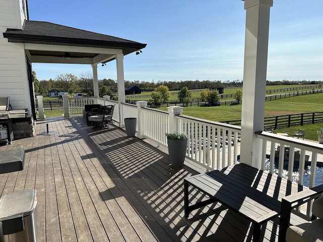 wooden deck featuring a yard and a rural view