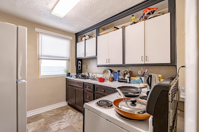 kitchen featuring a textured ceiling, white cabinetry, and white electric range oven