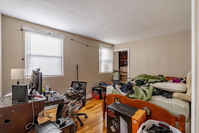 bedroom featuring a textured ceiling and light hardwood / wood-style floors