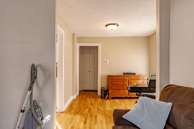 sitting room with a textured ceiling and light hardwood / wood-style flooring