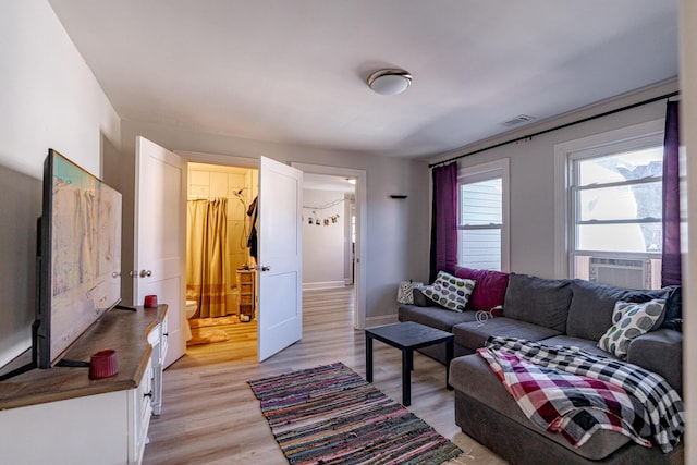 living room with cooling unit and light hardwood / wood-style floors