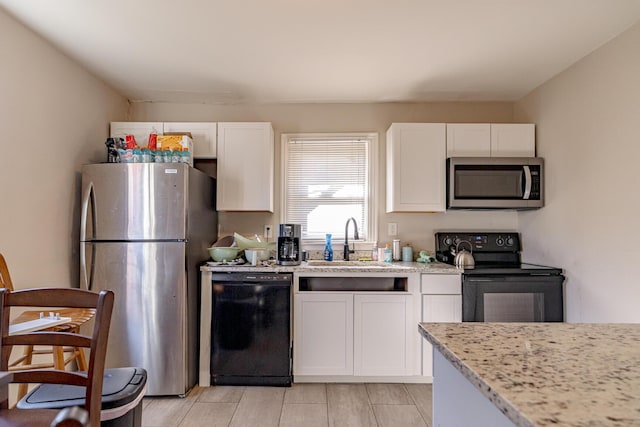 kitchen featuring black appliances, white cabinetry, and sink