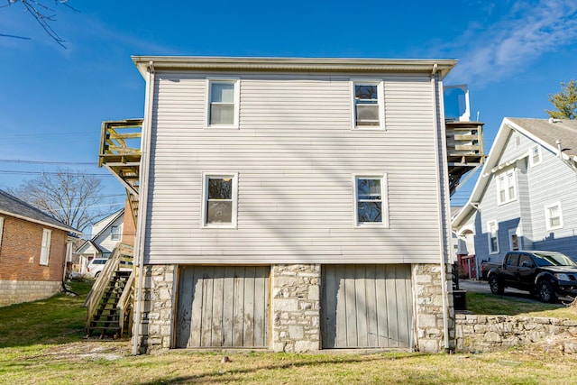 rear view of property featuring a garage and a yard