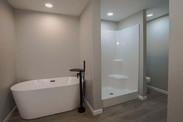 bathroom with toilet, separate shower and tub, and wood-type flooring