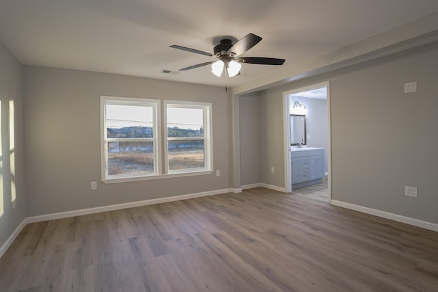 empty room with ceiling fan and light hardwood / wood-style floors