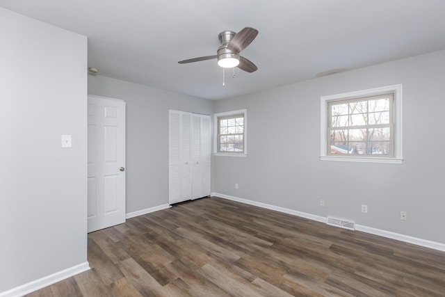 unfurnished bedroom with ceiling fan and dark hardwood / wood-style floors