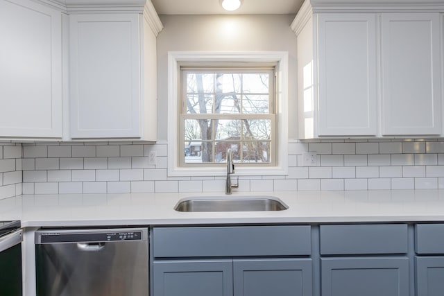 kitchen featuring decorative backsplash, stainless steel dishwasher, white cabinets, and sink