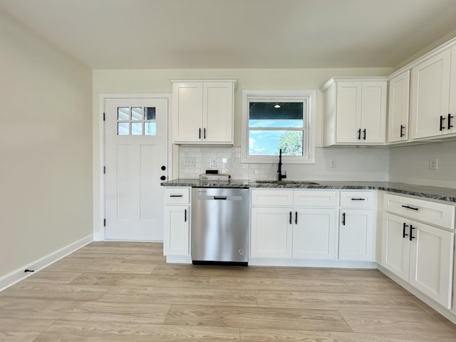 kitchen featuring sink, dark stone counters, dishwasher, and white cabinetry