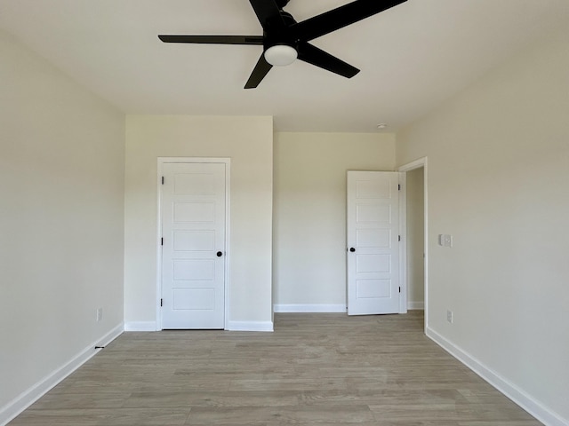 unfurnished bedroom with ceiling fan and light wood-type flooring