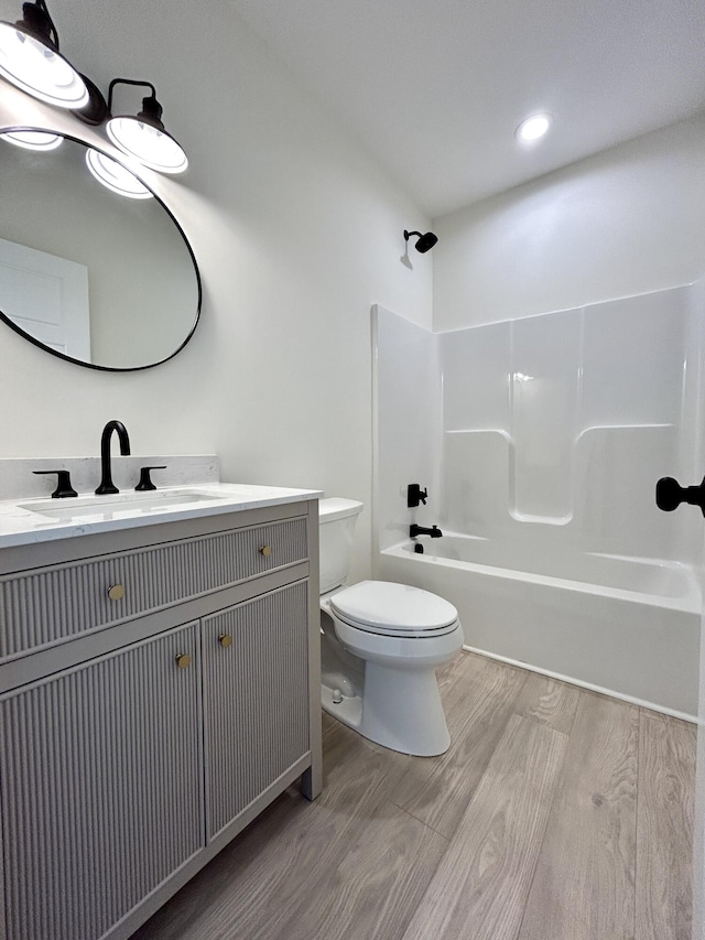 full bathroom with toilet, vanity, hardwood / wood-style floors, and  shower combination