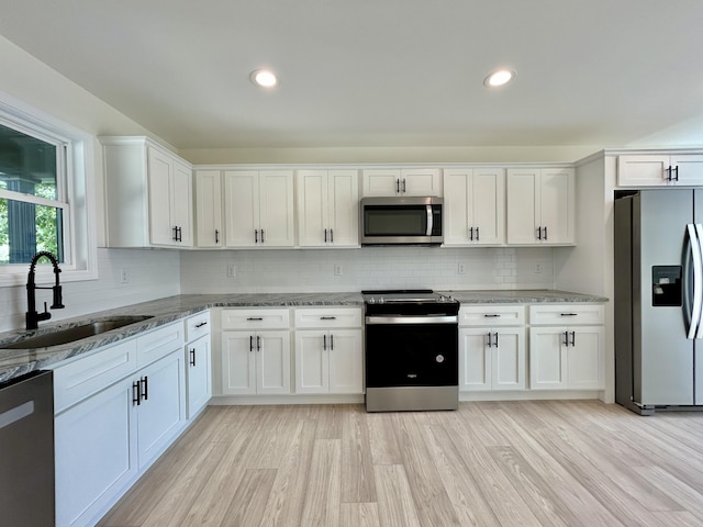 kitchen with sink, white cabinets, and appliances with stainless steel finishes