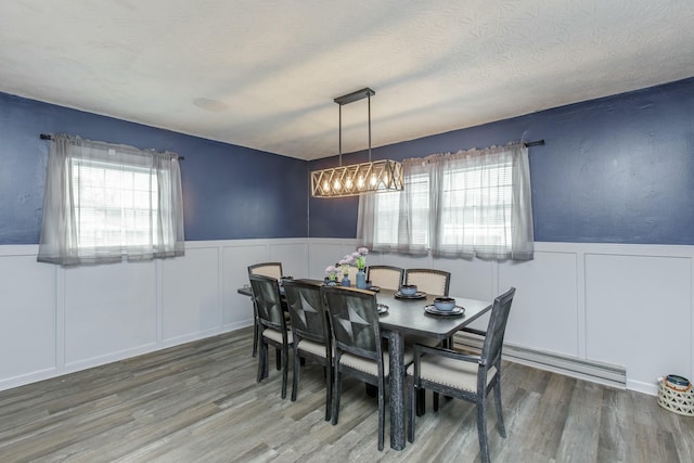 dining space with a textured ceiling and hardwood / wood-style floors