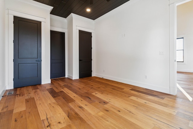 unfurnished bedroom with light wood-type flooring, wood ceiling, and crown molding