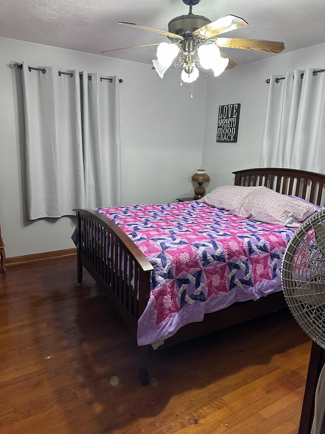 bedroom with ceiling fan, a textured ceiling, and hardwood / wood-style flooring