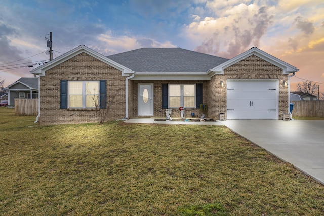 ranch-style home featuring a garage and a yard