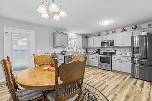 dining area with a chandelier and light hardwood / wood-style floors