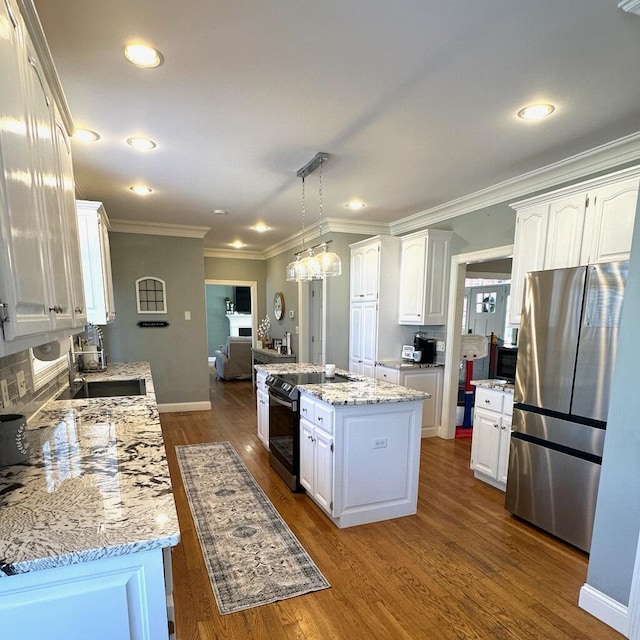 kitchen with electric stove, decorative light fixtures, a center island, white cabinets, and stainless steel fridge