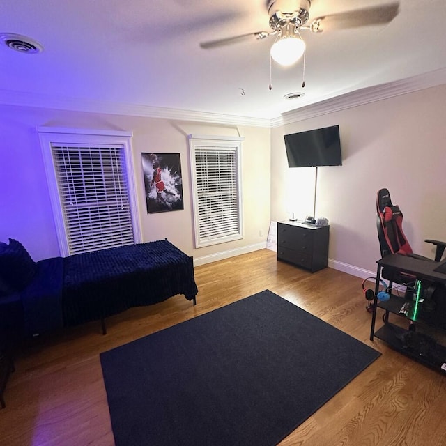 bedroom featuring ceiling fan, ornamental molding, and hardwood / wood-style flooring