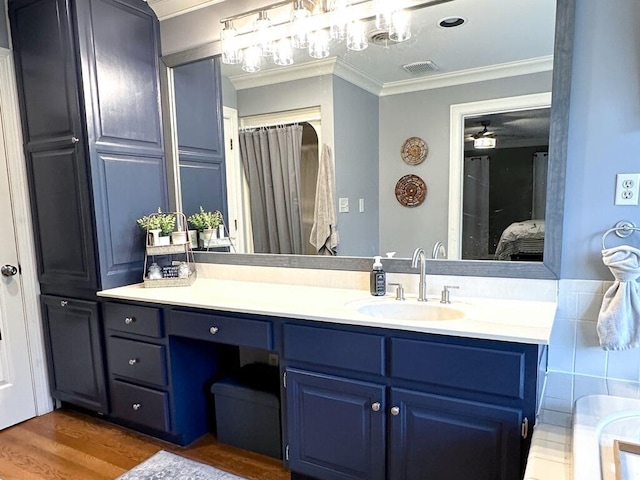 bathroom with ceiling fan, ornamental molding, hardwood / wood-style floors, and vanity