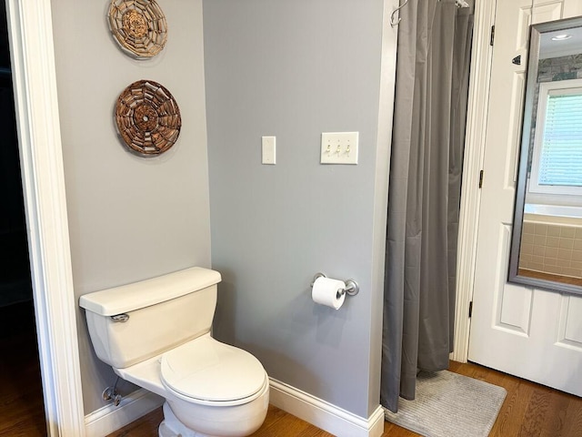 bathroom with toilet and hardwood / wood-style flooring