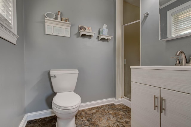 bathroom with toilet, a shower with shower door, and vanity