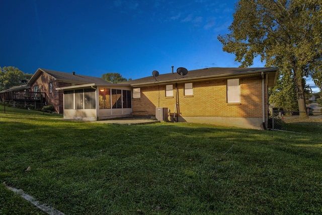 rear view of property featuring a yard and a sunroom