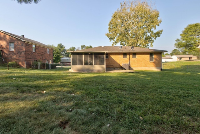 back of property with a yard and a sunroom