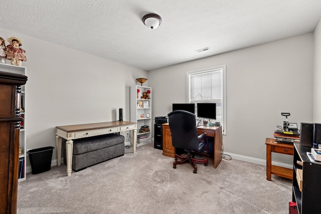 carpeted office space featuring a textured ceiling