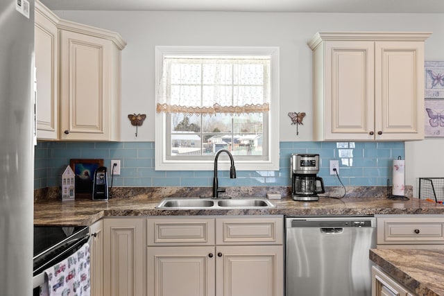 kitchen with appliances with stainless steel finishes, decorative backsplash, cream cabinets, and sink