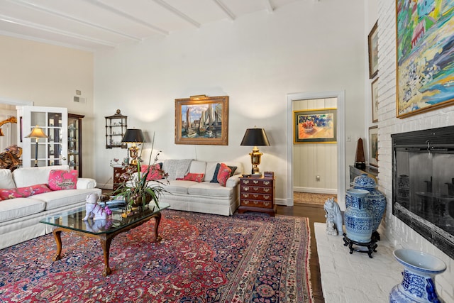 living room with beam ceiling and a fireplace