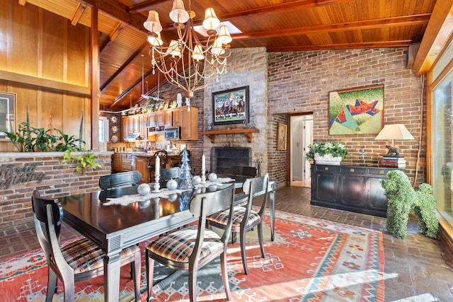 dining space with a notable chandelier, beamed ceiling, brick wall, high vaulted ceiling, and wood ceiling