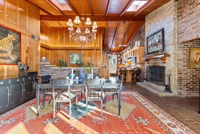 dining space featuring a chandelier, wooden walls, beamed ceiling, a fireplace, and wooden ceiling