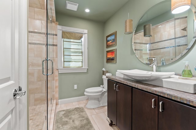 bathroom featuring vanity, tile patterned flooring, toilet, and a shower with shower door