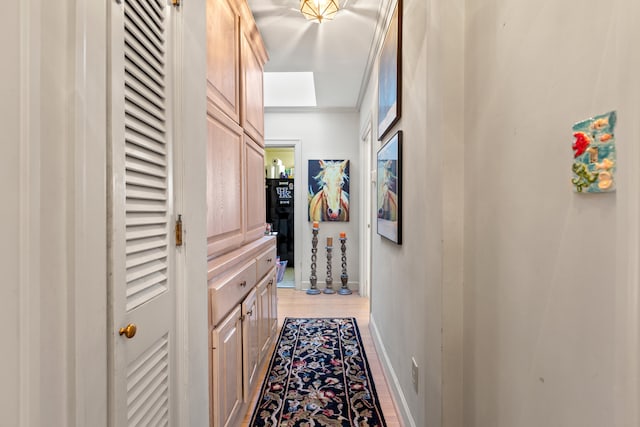 hall featuring light wood-type flooring and crown molding