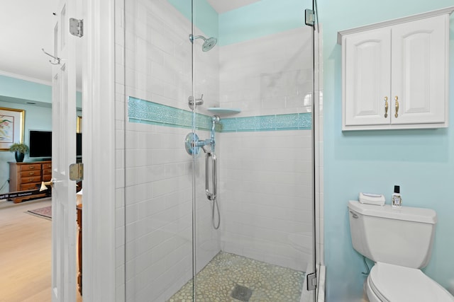 bathroom with toilet, walk in shower, and crown molding