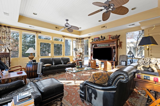 living room featuring wood ceiling, crown molding, and a tray ceiling