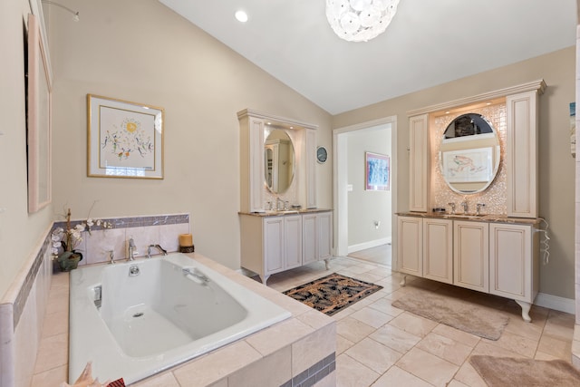 bathroom featuring a relaxing tiled tub, an inviting chandelier, vaulted ceiling, and vanity