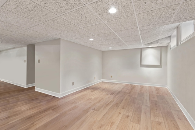 basement with a paneled ceiling and wood-type flooring