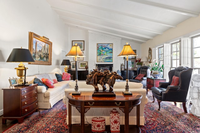 living room with a brick fireplace and lofted ceiling with beams