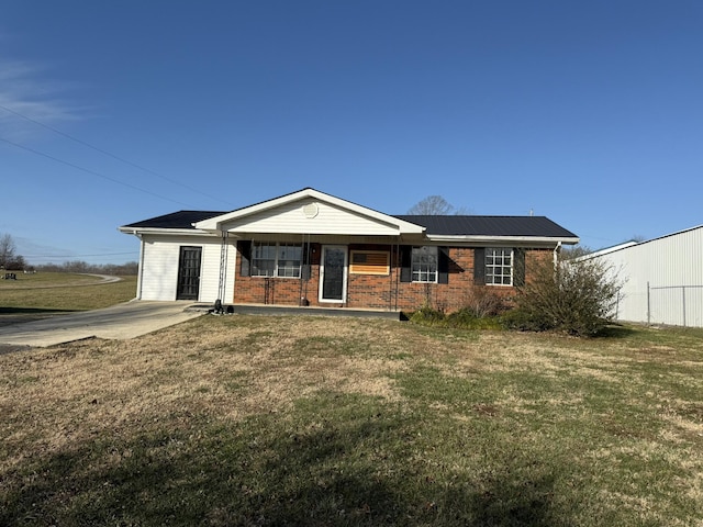 ranch-style home featuring a front lawn and covered porch