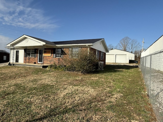 exterior space featuring an outdoor structure, a porch, a yard, and a garage